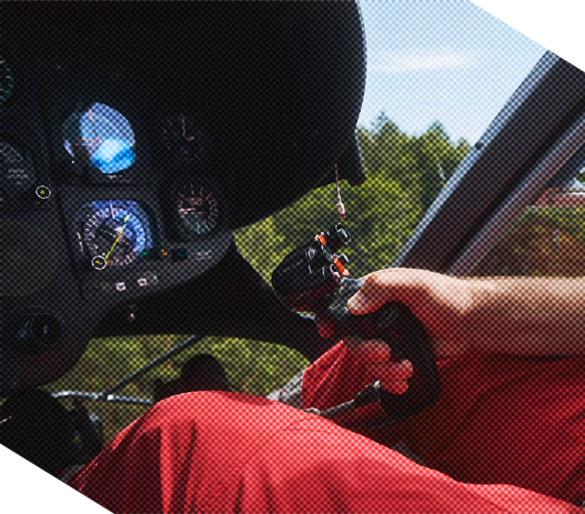 Person controlling helicopter joystick with cockpit instruments visible.