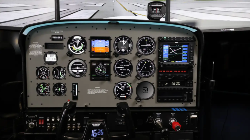 Aircraft cockpit with gauges, controls, and electronic displays in a simulator.