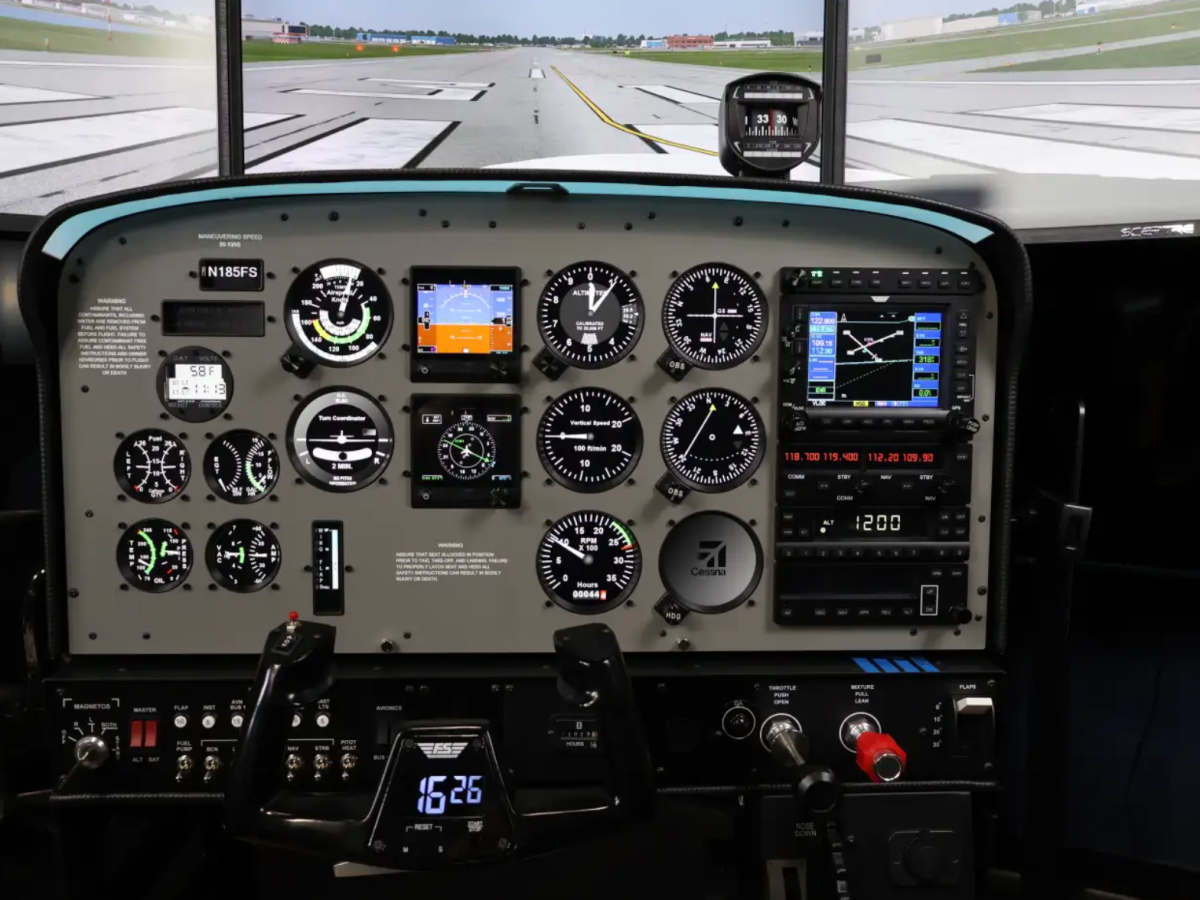 Aircraft cockpit with gauges, controls, and electronic displays in a simulator.