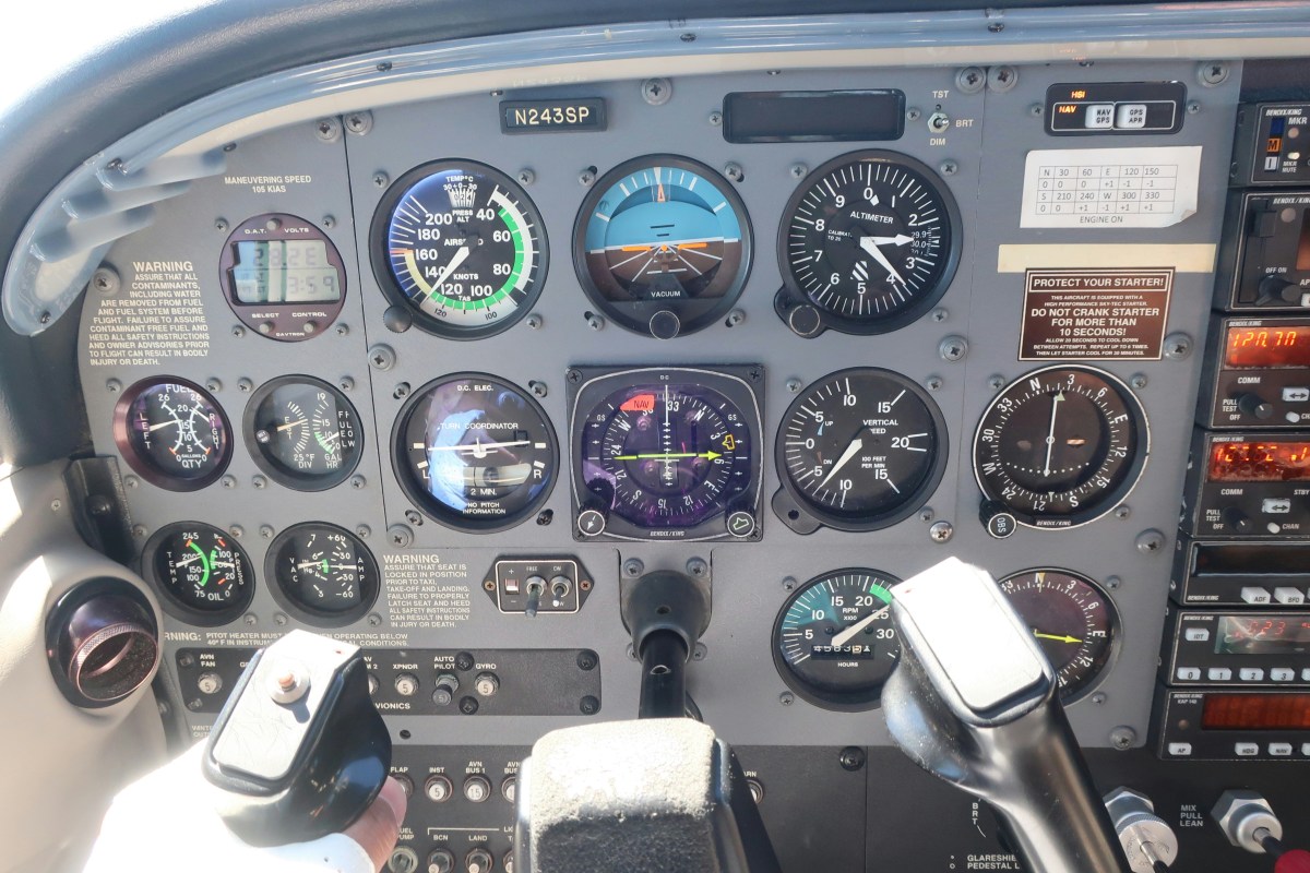 Airplane cockpit panel with gauges and controls, including altimeter and speed indicators.